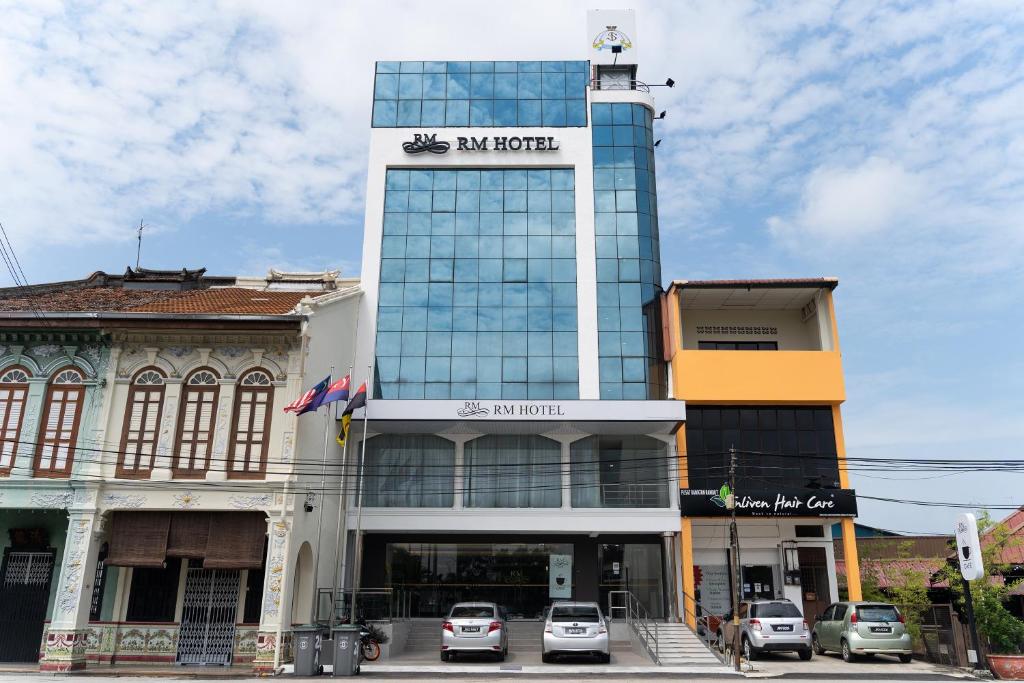 a tall building with cars parked in front of it at RM Hotel in Muar