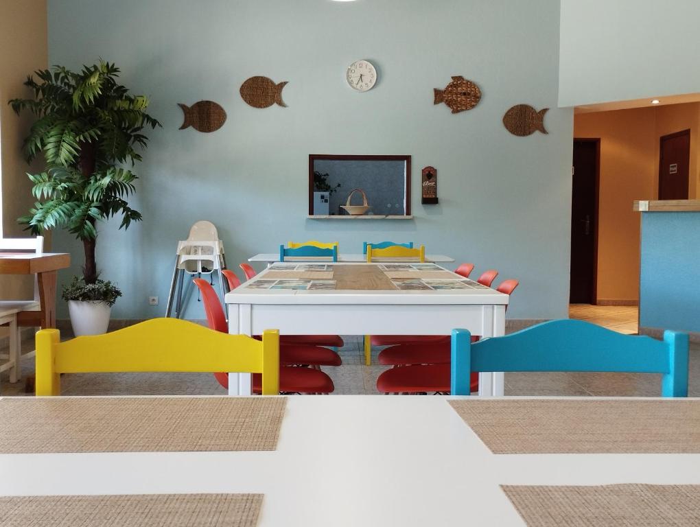 a dining room with a table with colorful chairs at CASA DA DUNA - Salir do Porto in Salir do Porto