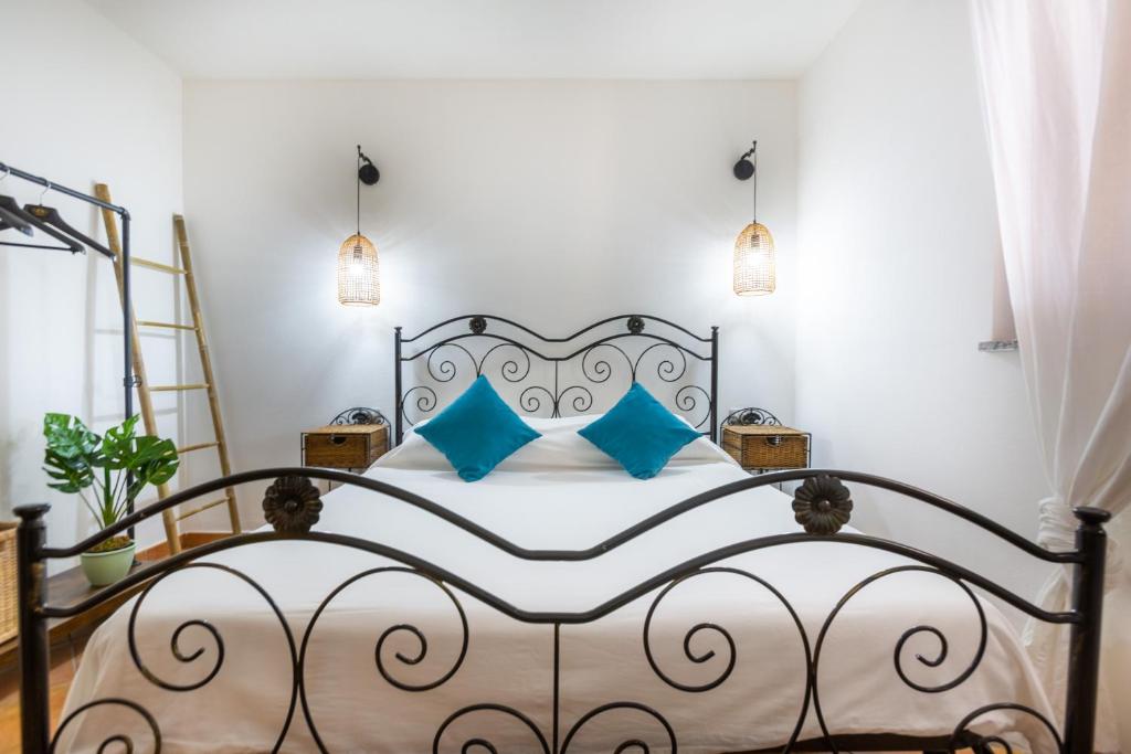Un dormitorio con una cama grande con almohadas azules. en Aetòs Home, Porto Pino hill, en Porto Pino