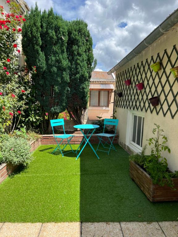 un patio avec deux chaises et une table dans une cour dans l'établissement Un break à Mers ?, à Mers-les-Bains