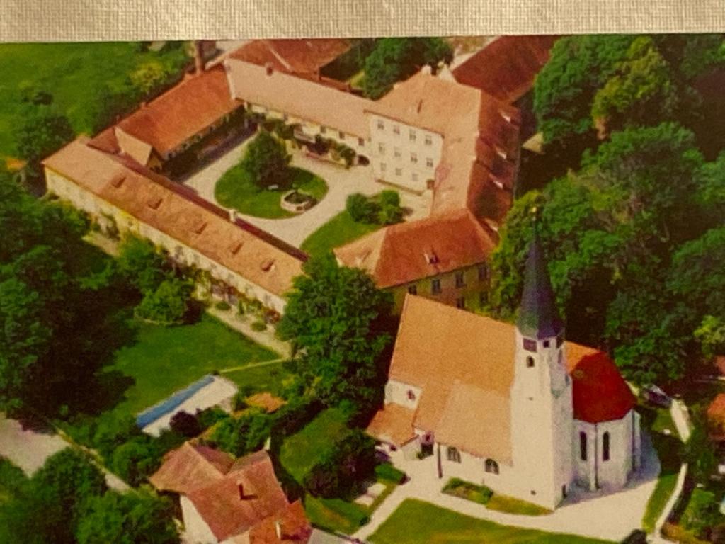 an aerial view of a large house with a church at Schlosspension Ering in Ering