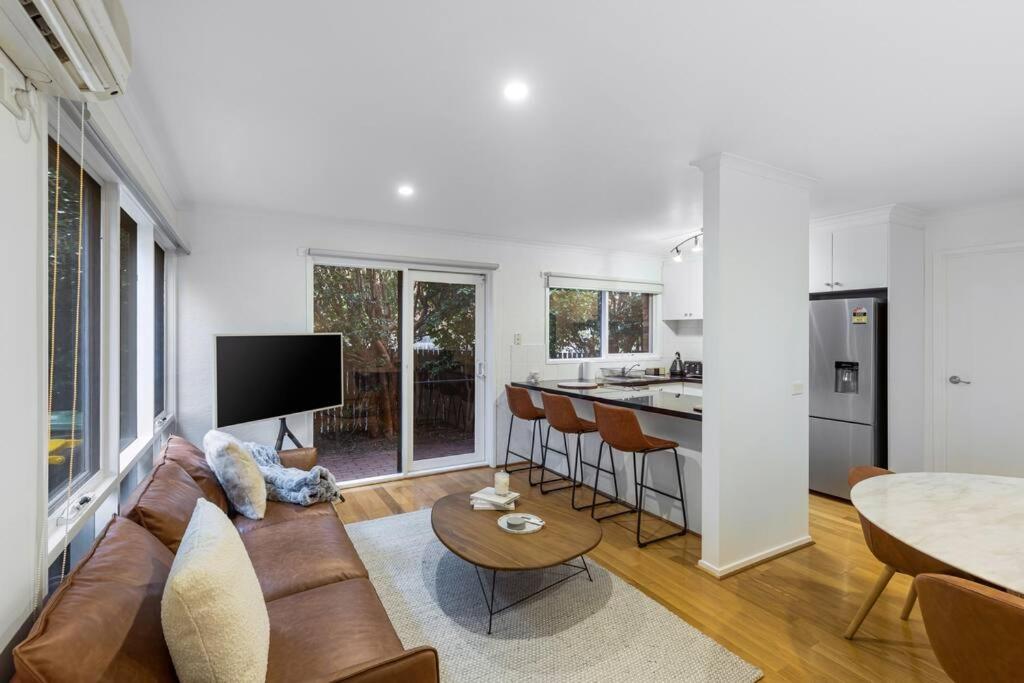 uma sala de estar com um sofá e uma cozinha em A Home away from home in Geelong em Geelong