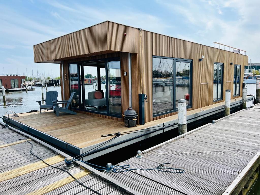 una pequeña casa en un muelle sobre el agua en Surla Houseboat "De Albatros" in Monnickendam Tender included, en Monnickendam