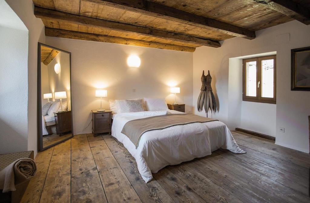 a bedroom with a large bed and a mirror at Verzasca Lodge Carlotta in Frasco