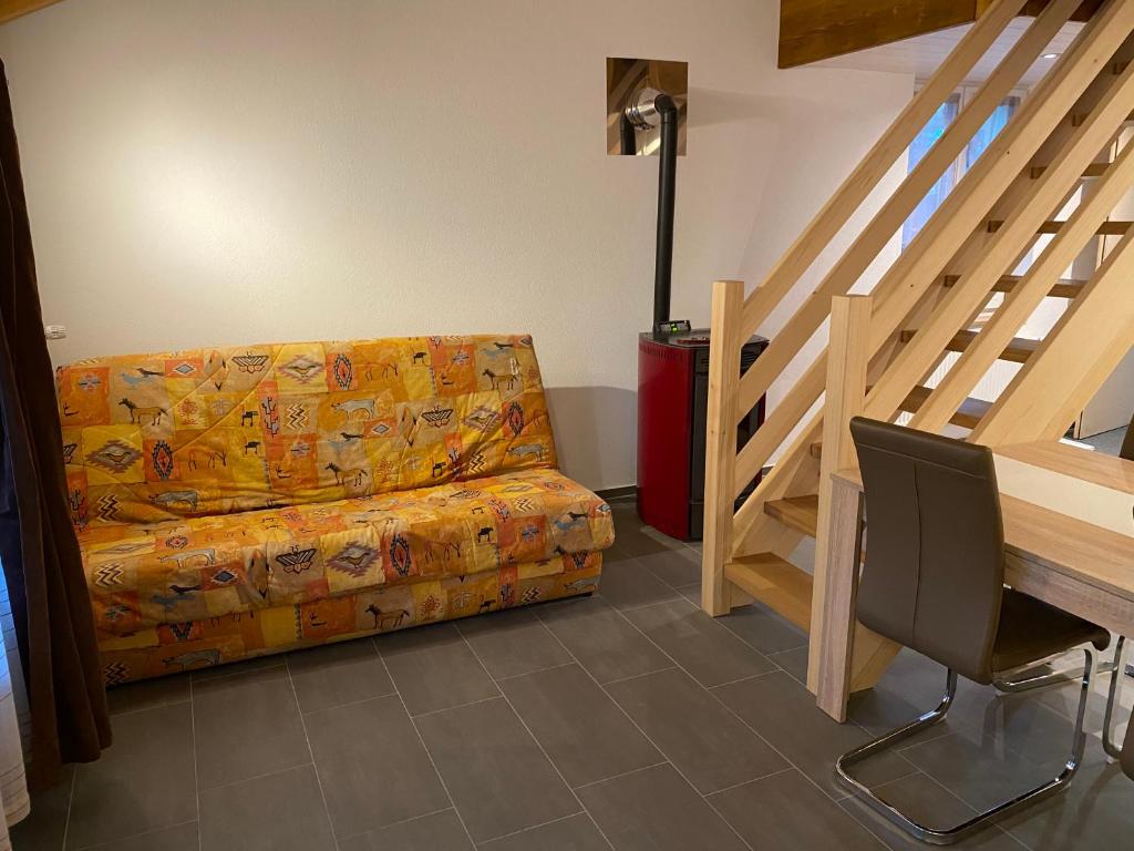 ein Wohnzimmer mit einem Sofa neben einer Treppe in der Unterkunft Bienvenue chez les Quadeurs 
