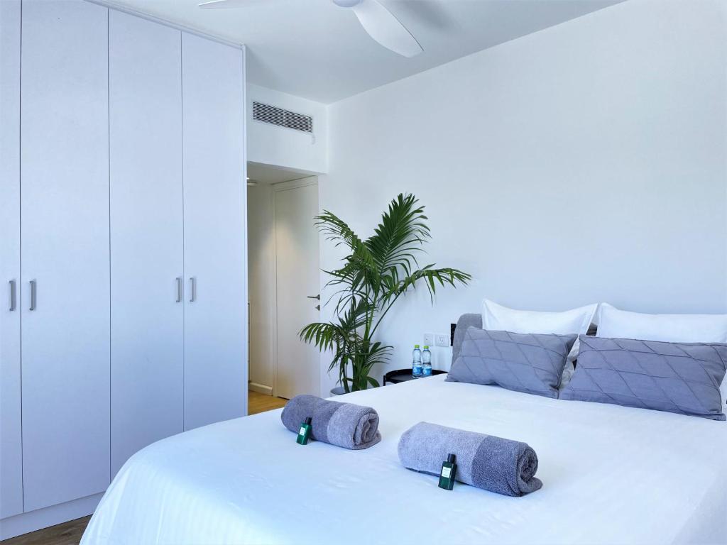 1 dormitorio con 1 cama blanca y 2 toallas en TEL AVIV - Sea front Penthouse - 1604, en Tel Aviv