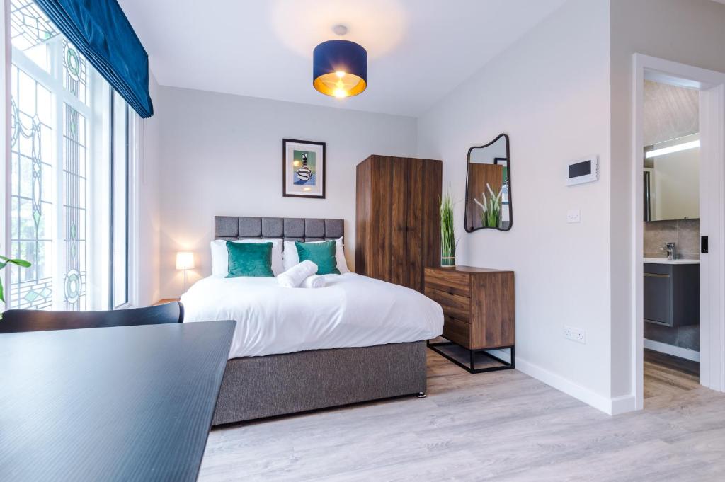a bedroom with a large bed and a table at Stylish, Central and Spacious Apartments in Southport in Southport