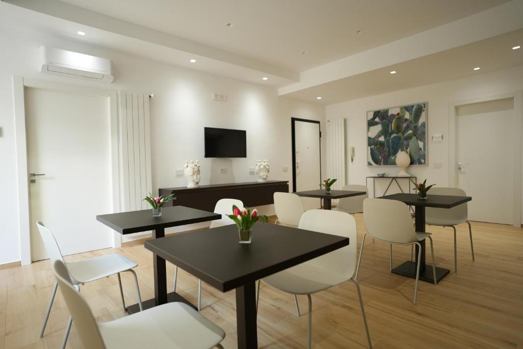 a living room with tables and chairs and a television at Enea Suite in Trapani