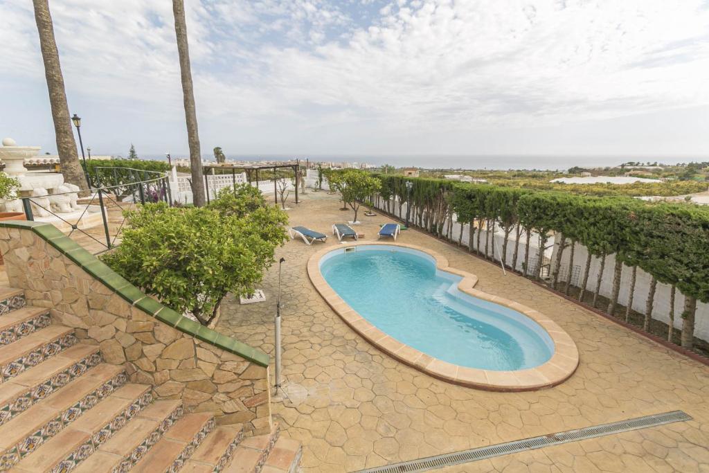 a swimming pool on a patio next to a staircase at Villa Los Leones Nerja in Nerja