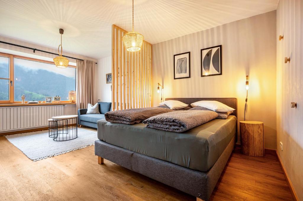Valentin36 Apartment Geisler في فونيس: غرفة نوم مع سرير وغرفة معيشة