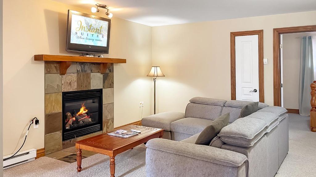a living room with a couch and a fireplace at The Mont-Tremblant Hideaway by InstantSuites in Mont-Tremblant