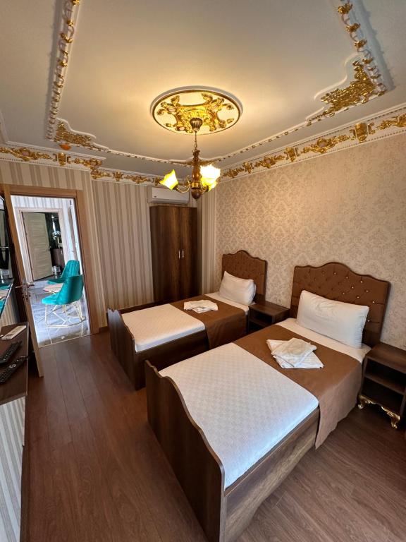 Cette chambre comprend deux lits et un lustre. dans l'établissement fafsuitehome, à Istanbul