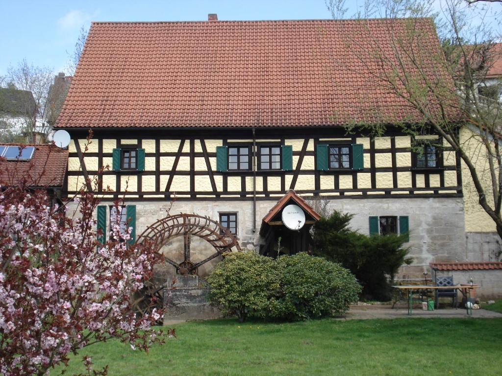 a black and white house with a clock on it at Hotel-Restaurant Bergmühle in Neudrossenfeld