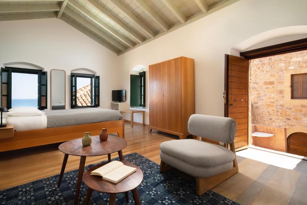 1 dormitorio con 1 cama, 1 mesa y 1 silla en Kalnterimi Guesthouses, en Monemvasia