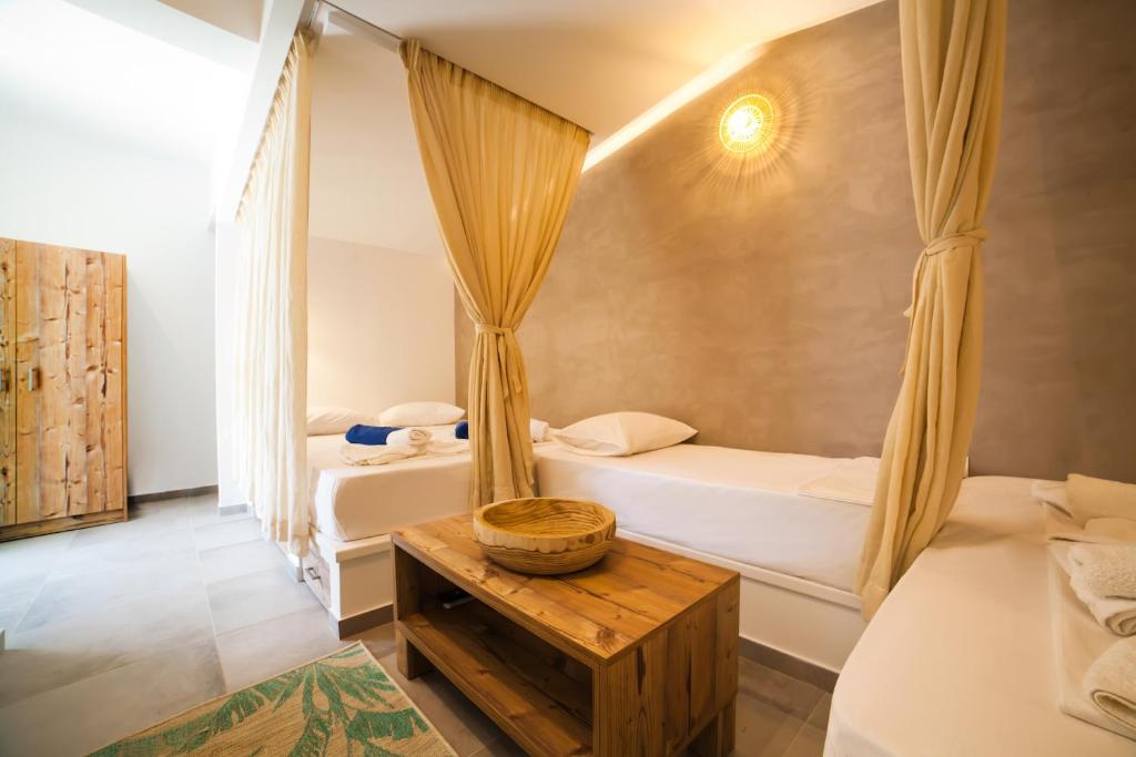 a bedroom with two beds and a table at SUITES DREAM TELENDOS in Kalymnos