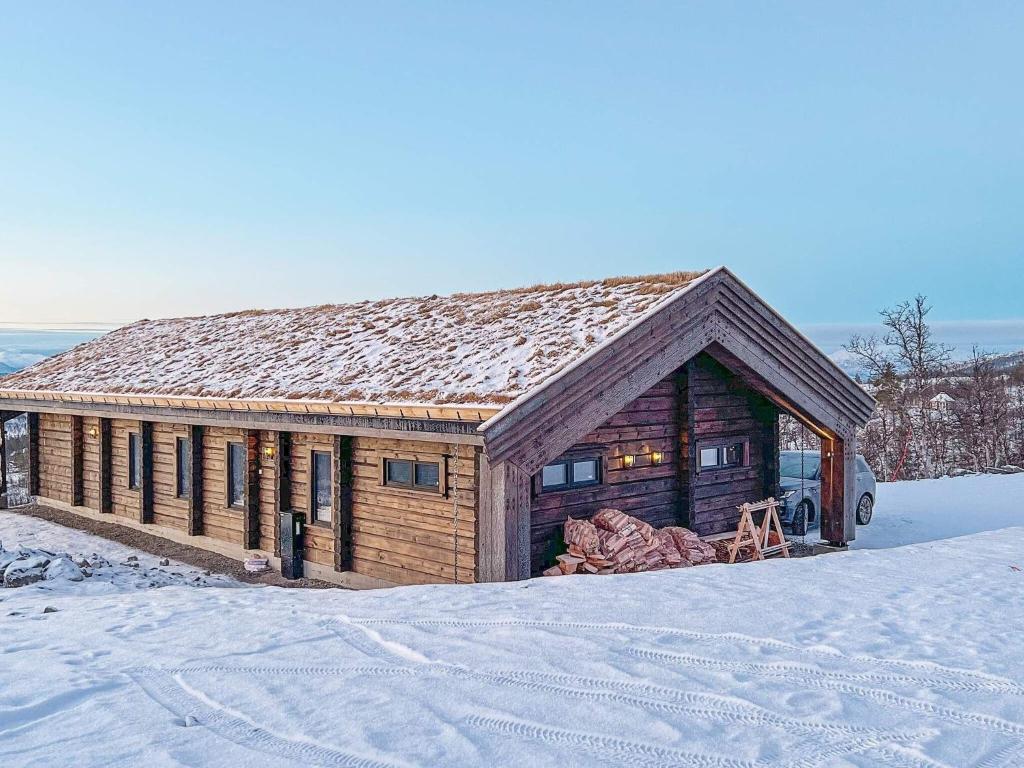 a log cabin with snow on the ground in front at 10 person holiday home in Moen-By Traum in Moen i Målselv