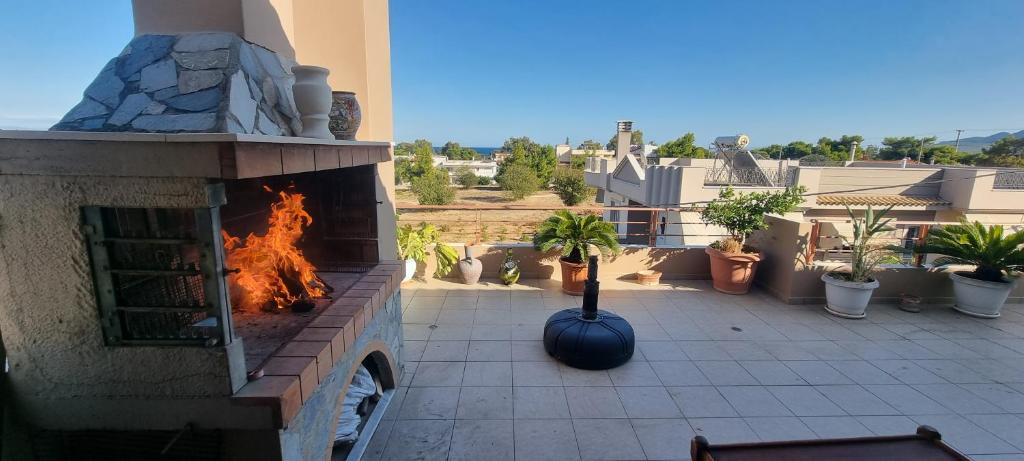 a patio with an outdoor fireplace on a house at Double bedroom on a villa in Artemida
