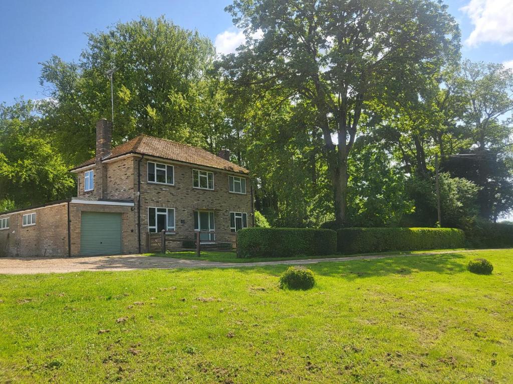 an old brick house with a garage in a yard at The Farmhouse - Linton Horseheath in Linton