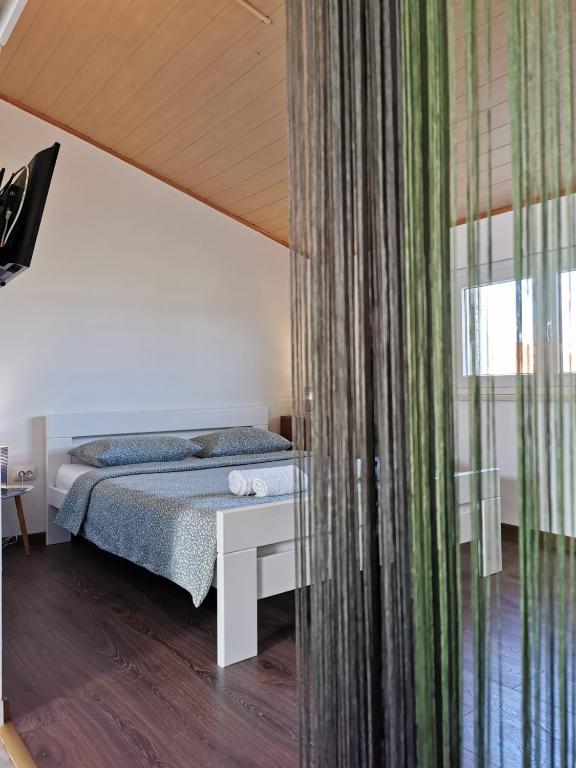a bedroom with a bed and a large window at Apartmani Vana 1 in Tribunj