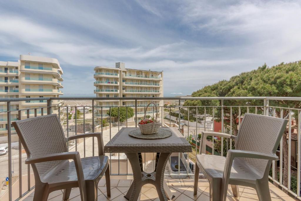 uma mesa e duas cadeiras numa varanda com vista para o oceano em Lido degli Estensi Seaview Apartment em Lido degli Estensi