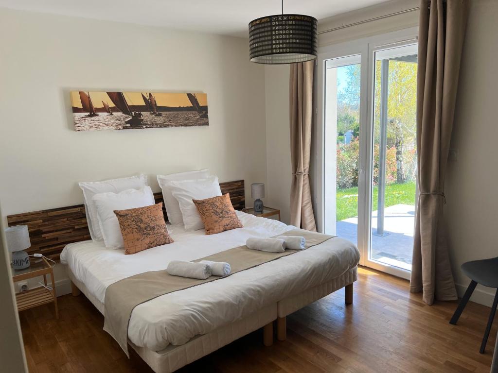 1 dormitorio con 1 cama con 2 almohadas en Les Mazades à 10 min de Périgueux avec piscine chauffée, meublé de tourisme classé 3 étoiles, en Annesse-et-Beaulieu