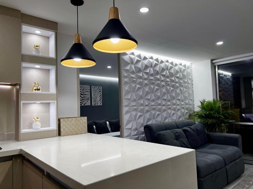 une cuisine avec un comptoir blanc et deux lumières dans l'établissement Apartamento luxury Girardot, à Girardot