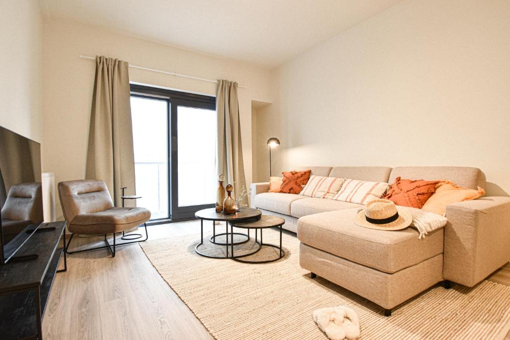 sala de estar con sofá y silla en Miramar Residences - Luxurious Seaside Apartments, en Blankenberge
