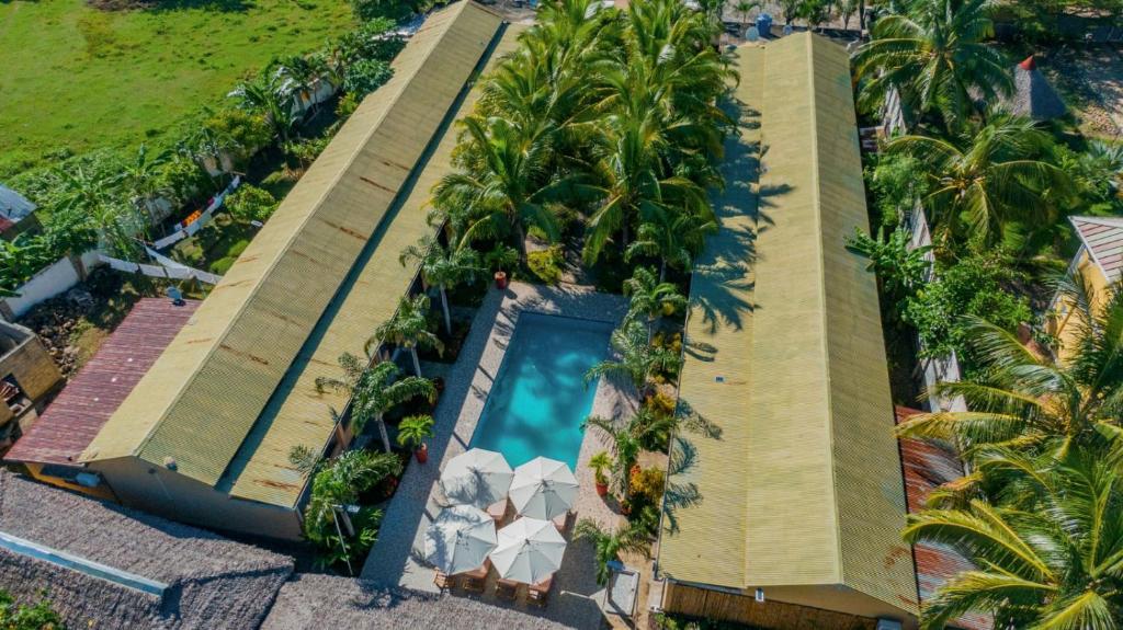 uma vista sobre um resort com uma piscina e palmeiras em Fleurs d'Ylang em Nosy Be