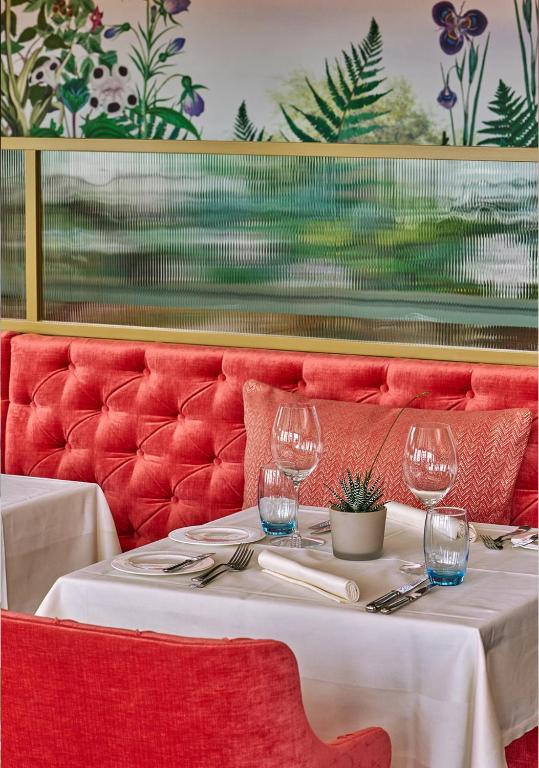 a table with three wine glasses on a red couch at Château Gütsch in Luzern
