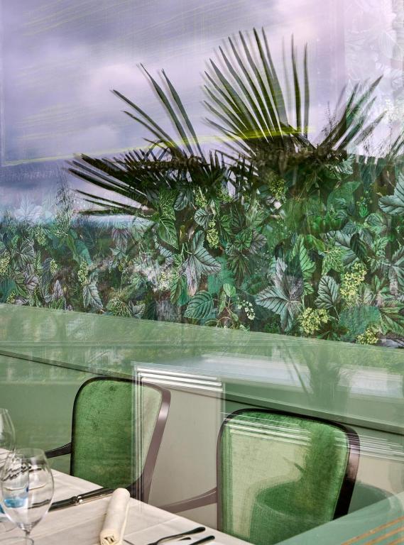 a table and chairs in a restaurant with a mural at Château Gütsch in Luzern