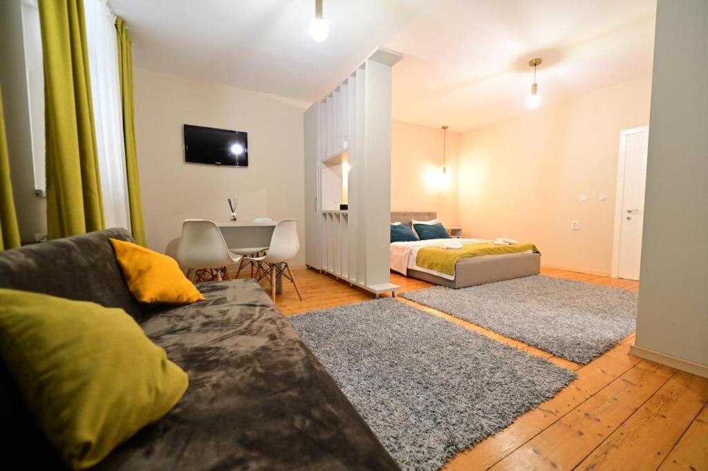 a living room with a couch and a bed at Grand Central Studios in Sibiu