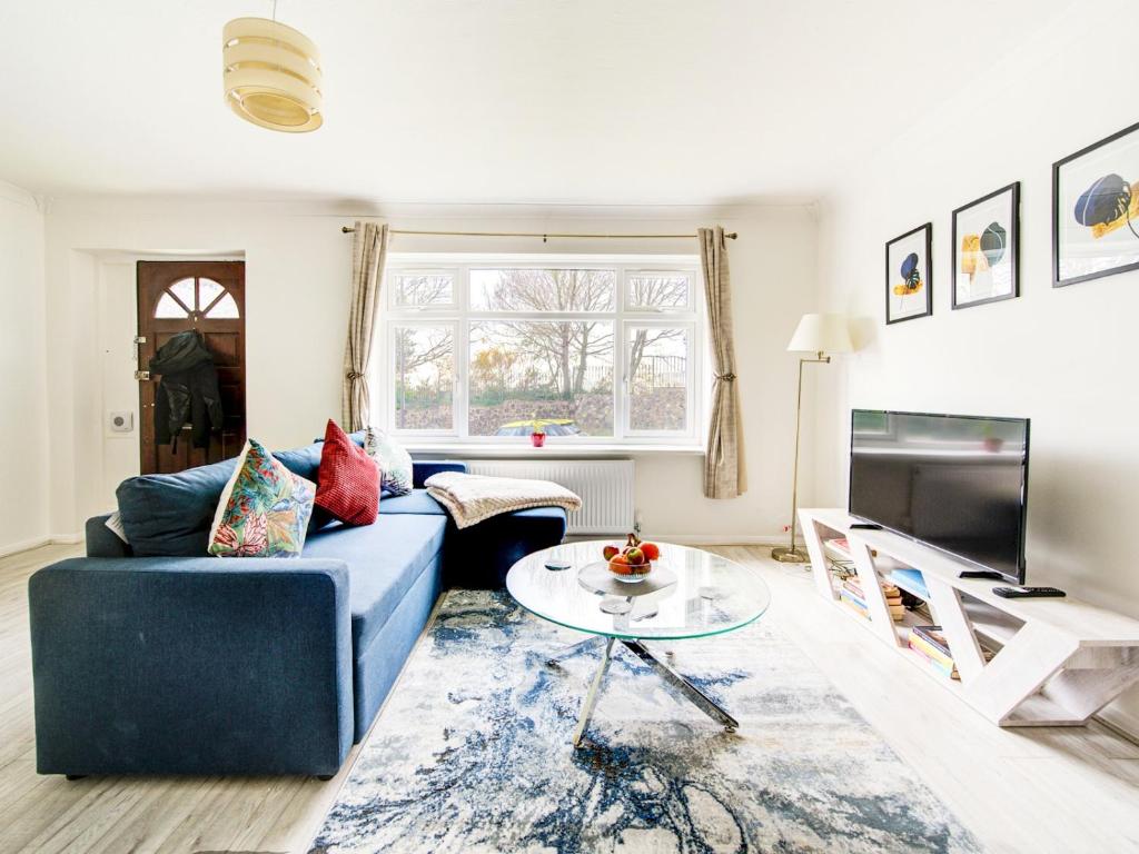 uma sala de estar com um sofá azul e uma mesa em Pass the Keys Bright Spacious Home Away From Home With Parking em Abbey Wood