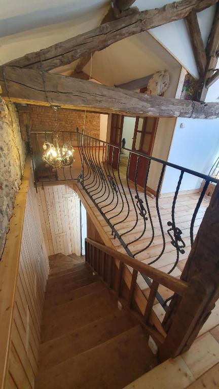 a spiral staircase in a building with a chandelier at Chateau Mano in Mairé-lʼEveseault