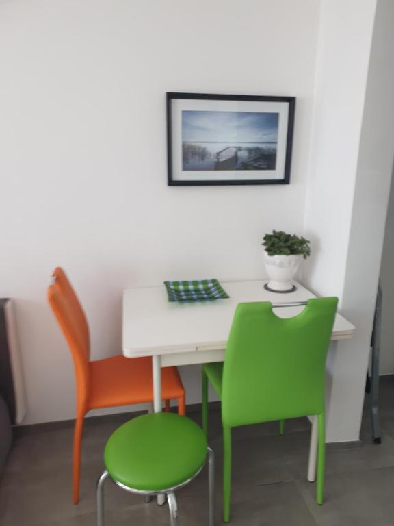 een witte tafel met twee stoelen en een groene stoel bij Apartman Liliana in Rijeka