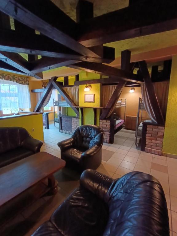 a living room with leather chairs and a fireplace at Studio nad Kanałem in Kłodzko