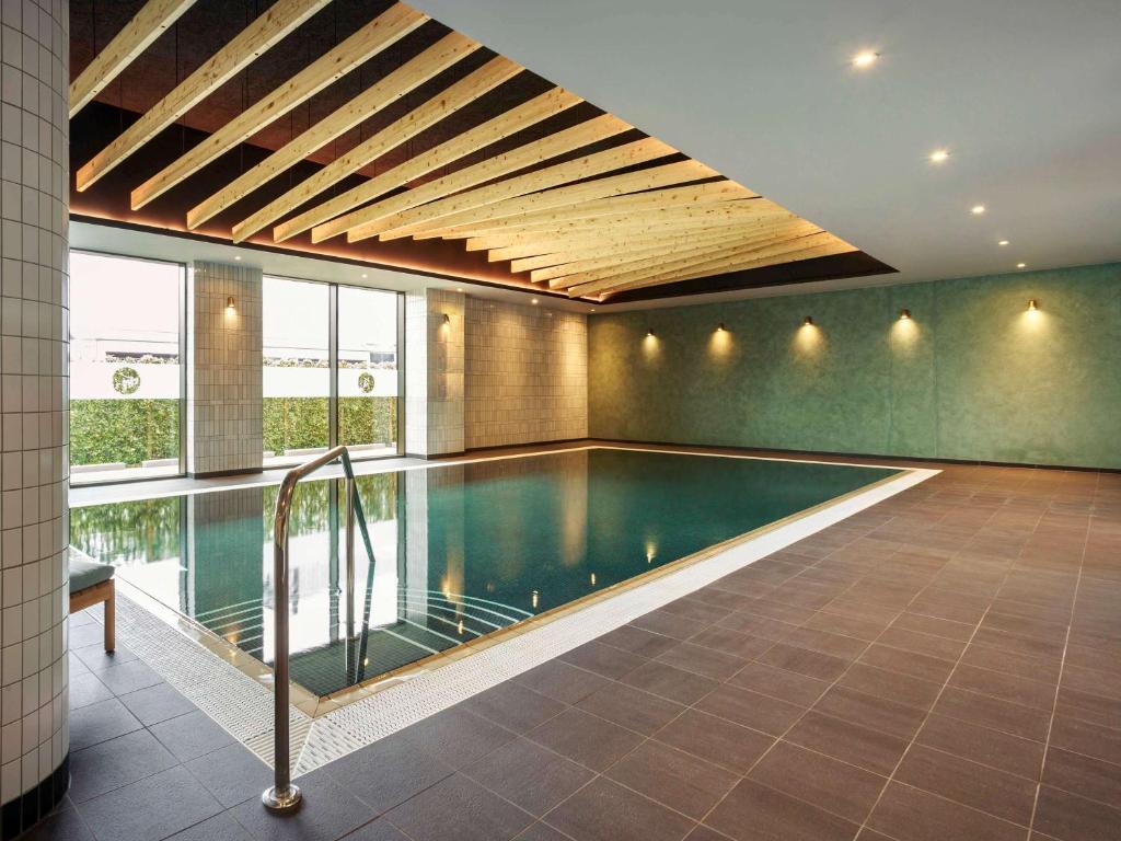 a swimming pool in a house with a ceiling at Novotel Cambridge North in Cambridge