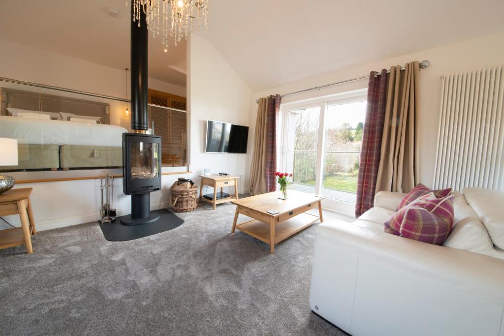 a living room with a white couch and a fireplace at Hawkshead Suites in Hawkshead