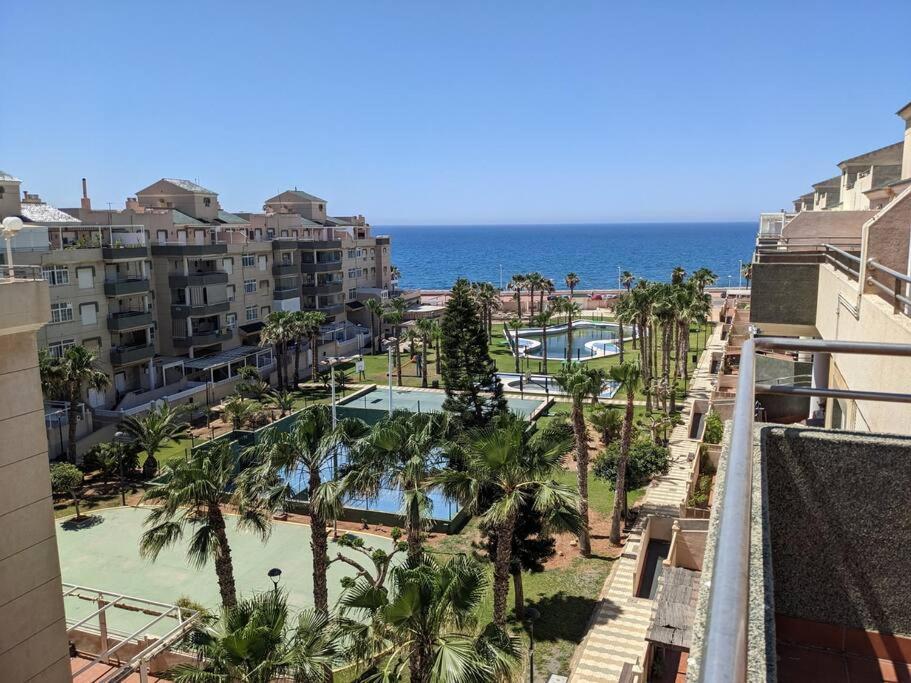 a view of a resort with palm trees and the ocean at ÁticoToyoAlmeria in Retamar