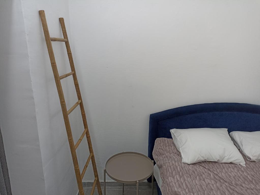 a wooden ladder next to a bed and a table at הבית של יעל in Tel Aviv