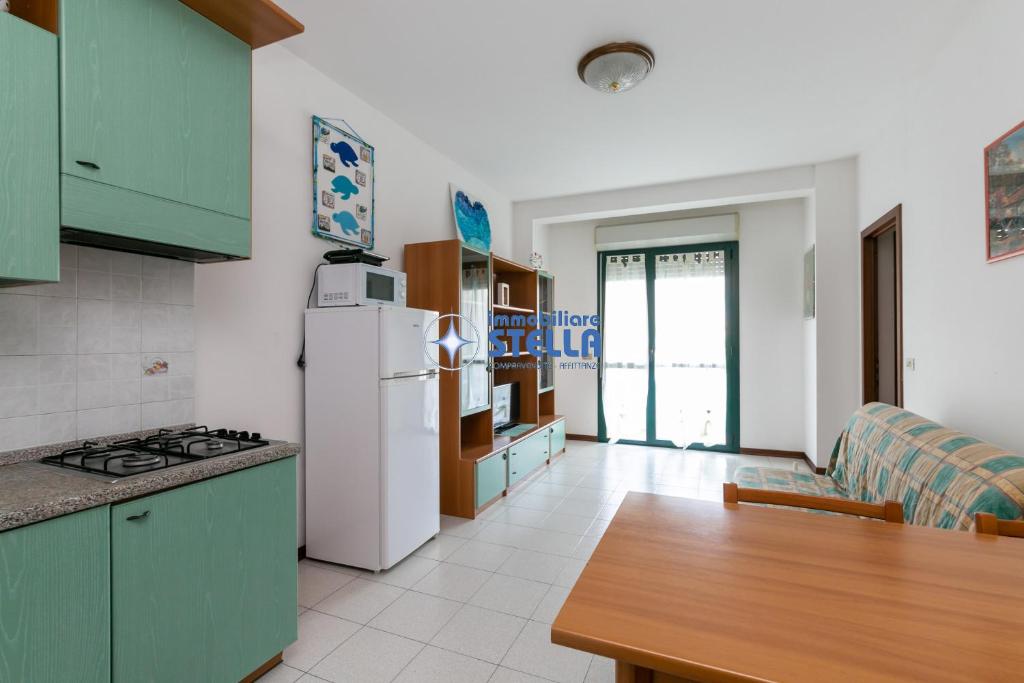 a kitchen with green cabinets and a white refrigerator at Costa Del Sol in Lido di Jesolo