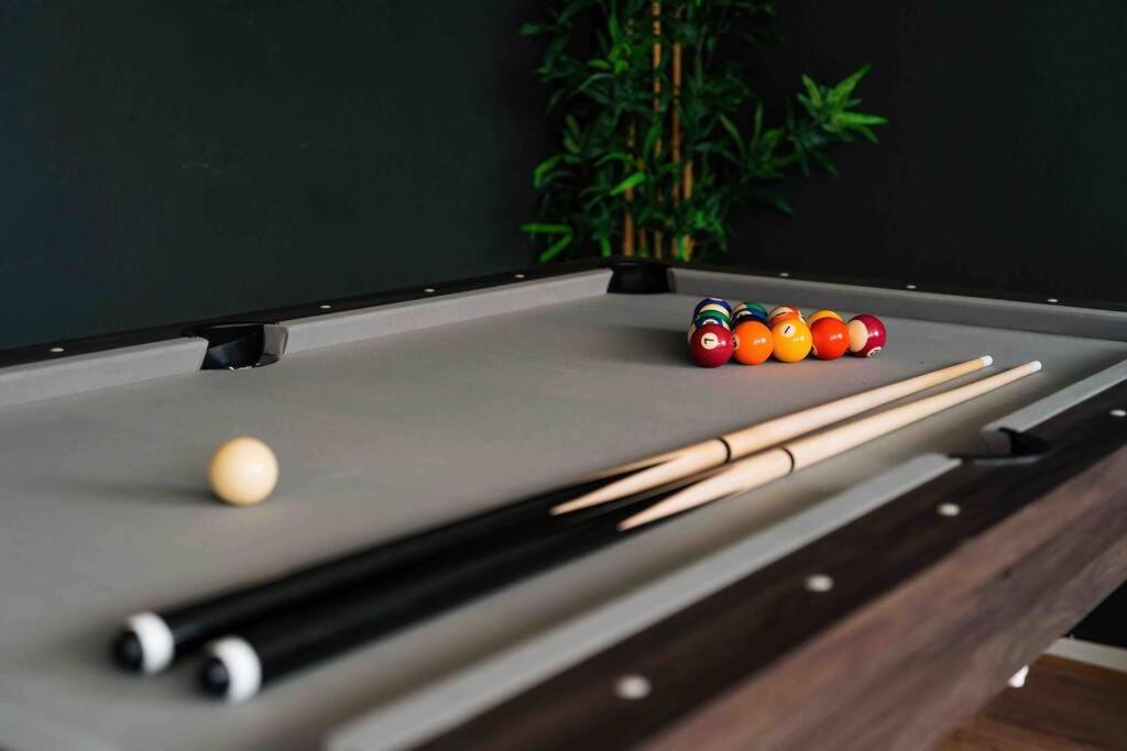 a pool table with two cue balls and cue sticks at Contractor base with Hot Tub and Pool table in London