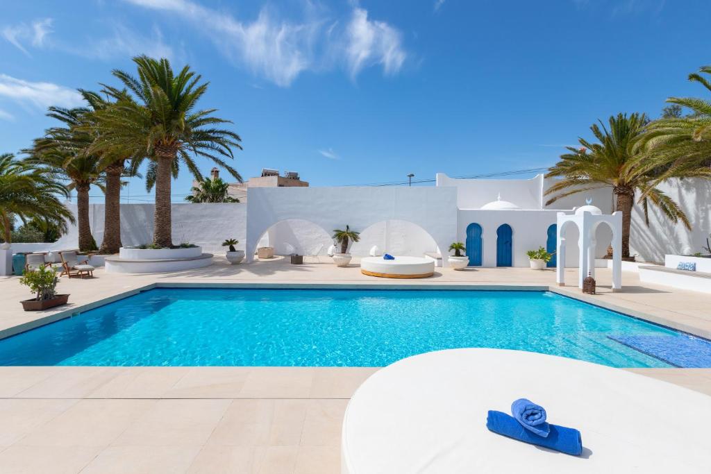 a villa with a swimming pool and palm trees at Luxury Mauresque Jazmin in Torremolinos