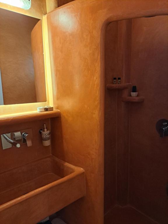 a bathroom with a sink and a mirror at Studios Irineos in Perissa