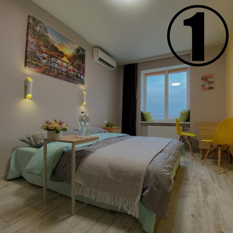 a bedroom with a king sized bed and a table at Studio Aparment in Kharkiv