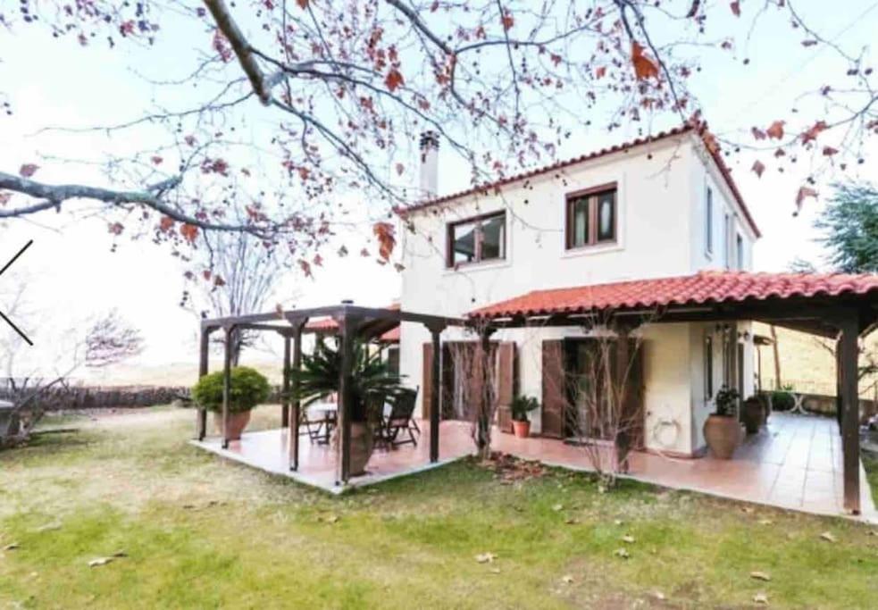 une maison blanche avec une terrasse couverte et une cour dans l'établissement Gerania Villa, à Písia