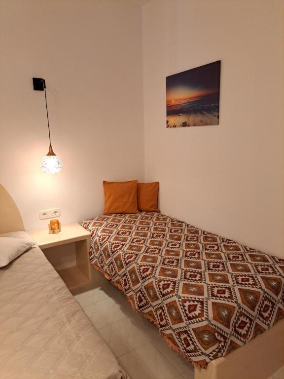 a bedroom with a bed and a table and a picture at Studios Irineos in Perissa