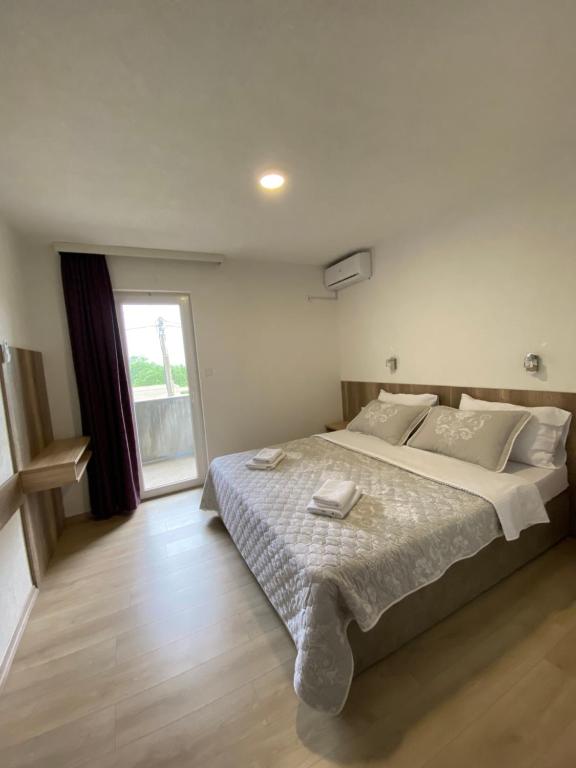 Un dormitorio con una cama grande y una ventana en Pansion Raspudić en Međugorje