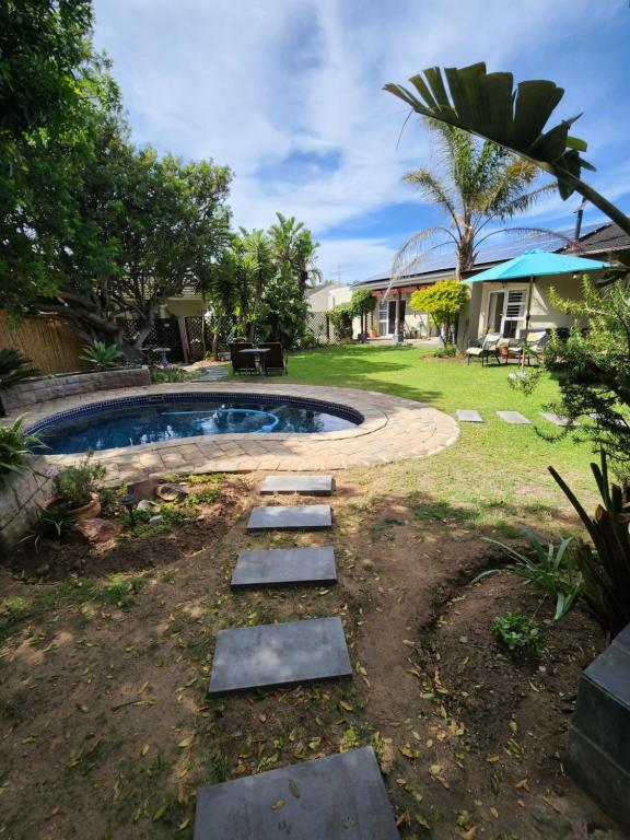 a backyard with a pool with a path around it at Jenvey House Selfcatering Apartments & BnB in Port Elizabeth