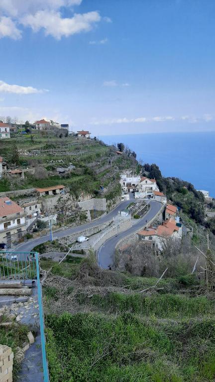 a winding road on a hill next to the ocean at Al Geranio B&B in Furore