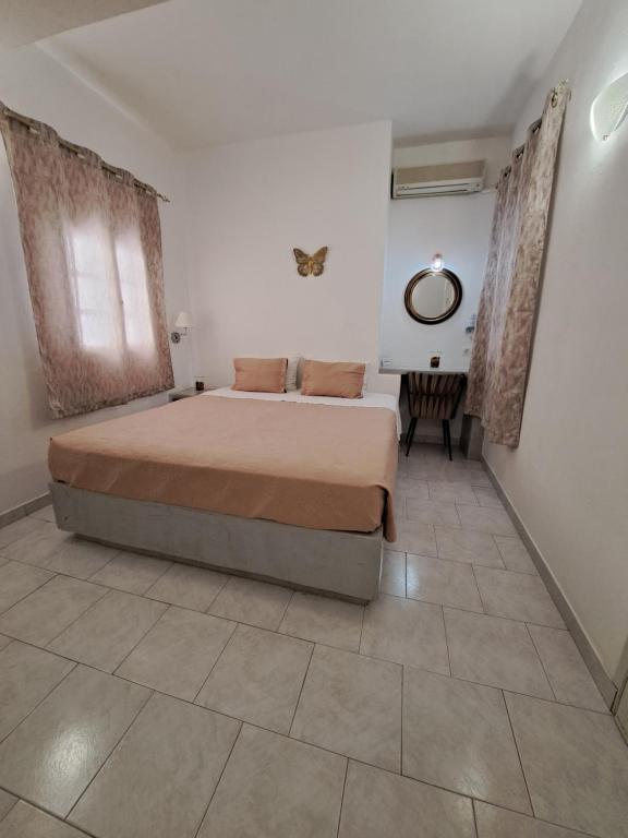 a bedroom with a large bed and a mirror at Studios Irineos in Perissa